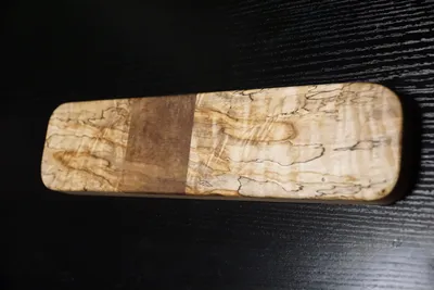 Rectangular clapper of heavily spalted maple with a plain walnut band across the center