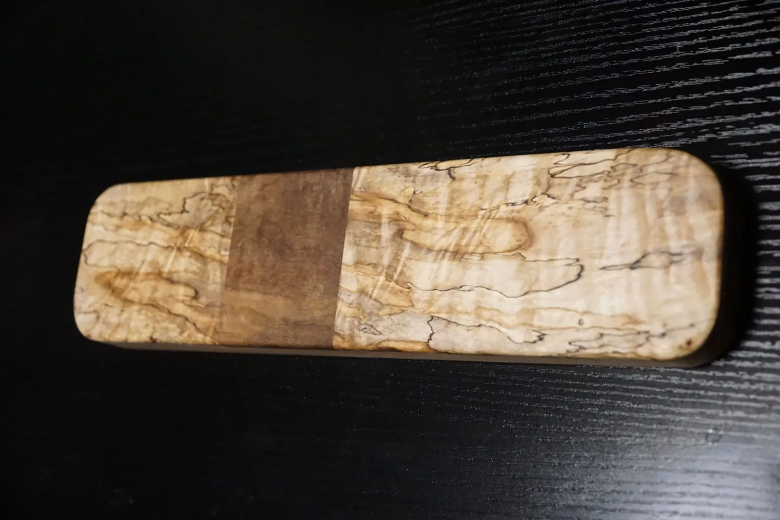Rectangular clapper of heavily spalted maple with a plain walnut band across the center