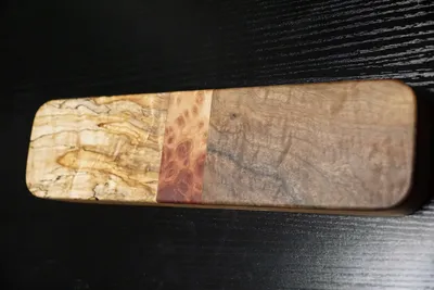 Rectangular clapper pieced from maple burl, a lace red mallee burl band, and figured walnut