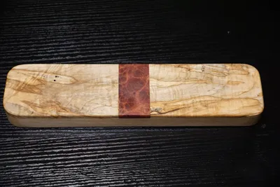 Rectangular clapper of spalted curly maple with a red mallee burl band across the center